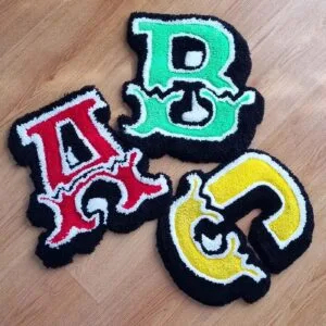 Composición de tres alfombras en forma de letra: cada alfombra letra decorativa representa una inicial diferente.