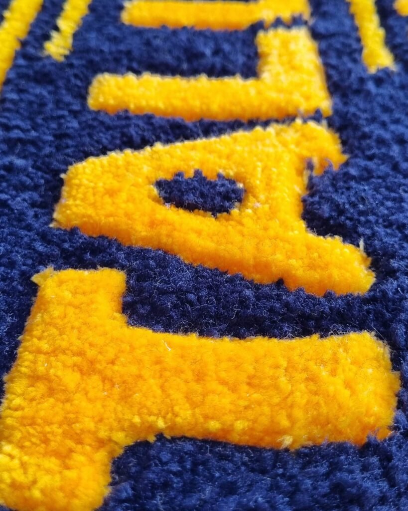 Detalle del nombre Taller #5 en alfombra personalizada con logotipo, ejemplo de alfombras personalizadas.